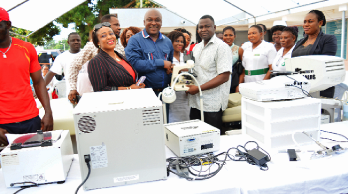 Mr Ahenkorah (middle) being supported by his wife (left) to present the items to Dr Julius Tsidi (right), the acting Medical Superintendent of the Tema Polyclinic